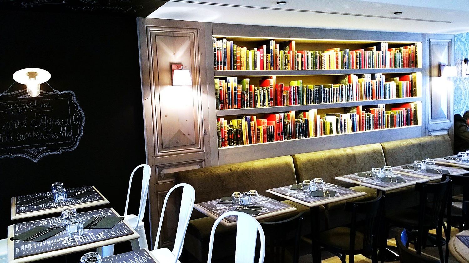 Une salle du Comptoir du Narval : banquettes, tables et mur de livres