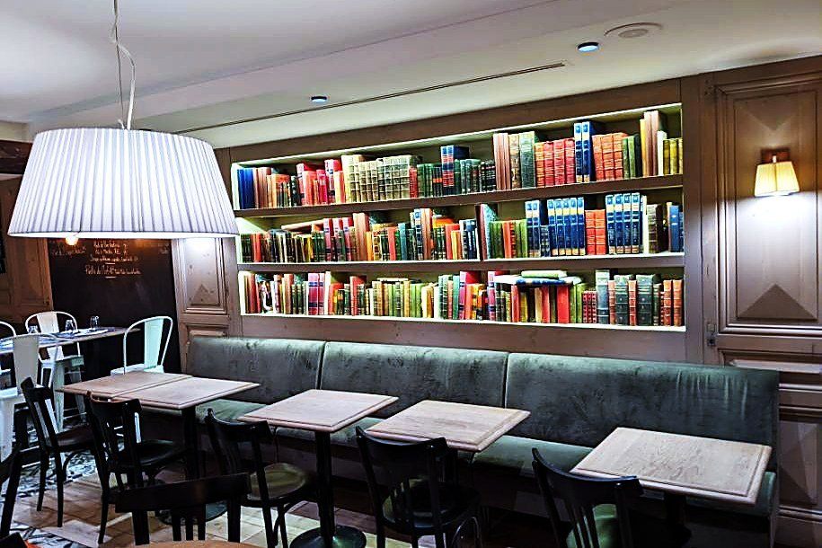 Une des salles du Comptoir du Narval, murs habillés de livres